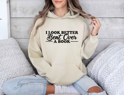 Person wearing a sand hoodie with text, sitting on a couch.