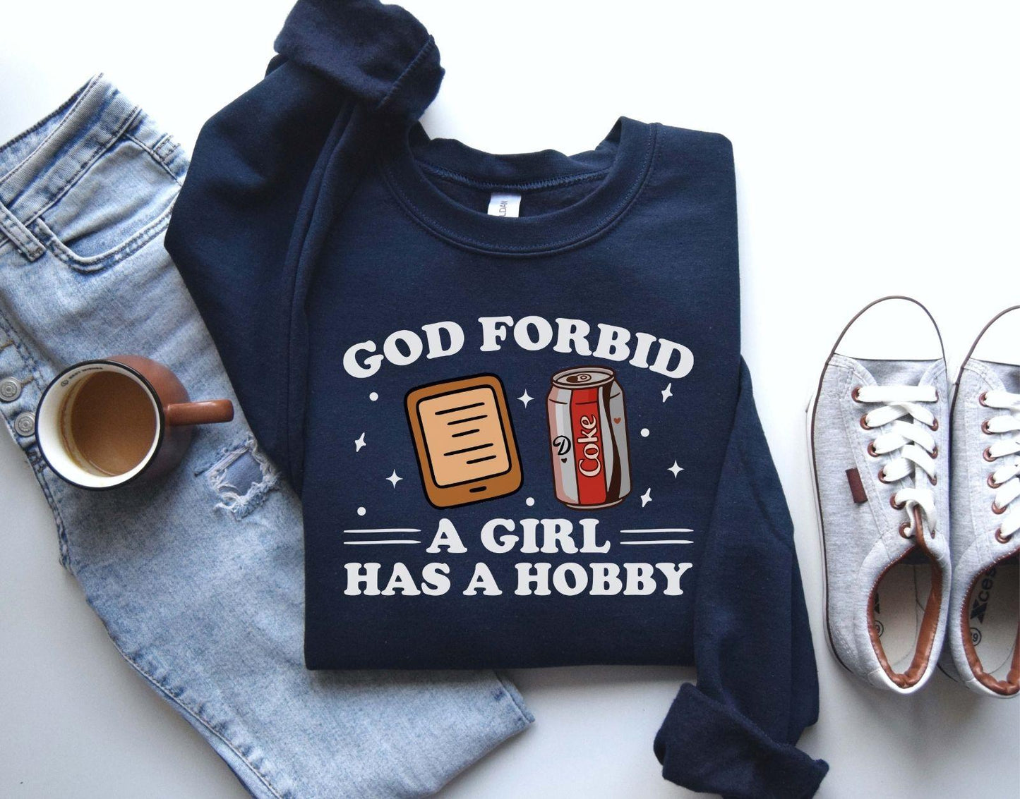 A Gildan 18000 sweatshirt with the saying "god forbid a girl has a hobby"