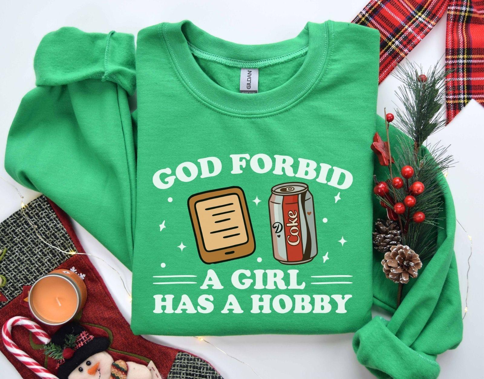 A Gildan 18000 sweatshirt with the saying "god forbid a girl has a hobby"