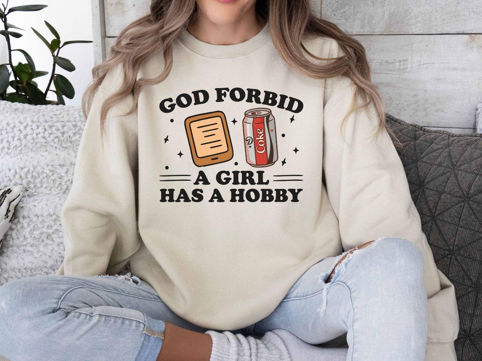 A Gildan 18000 sweatshirt with the saying "god forbid a girl has a hobby"