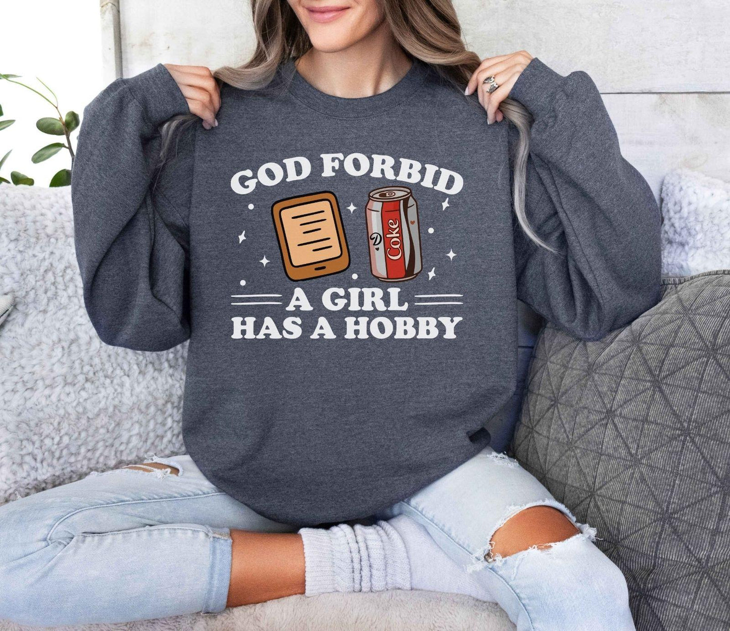 A Gildan 18000 sweatshirt with the saying "god forbid a girl has a hobby"