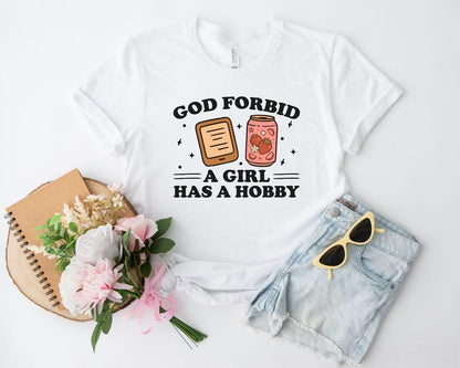 A bella canvas 3001 shirt with the saying "god forbid a girl has a hobby"