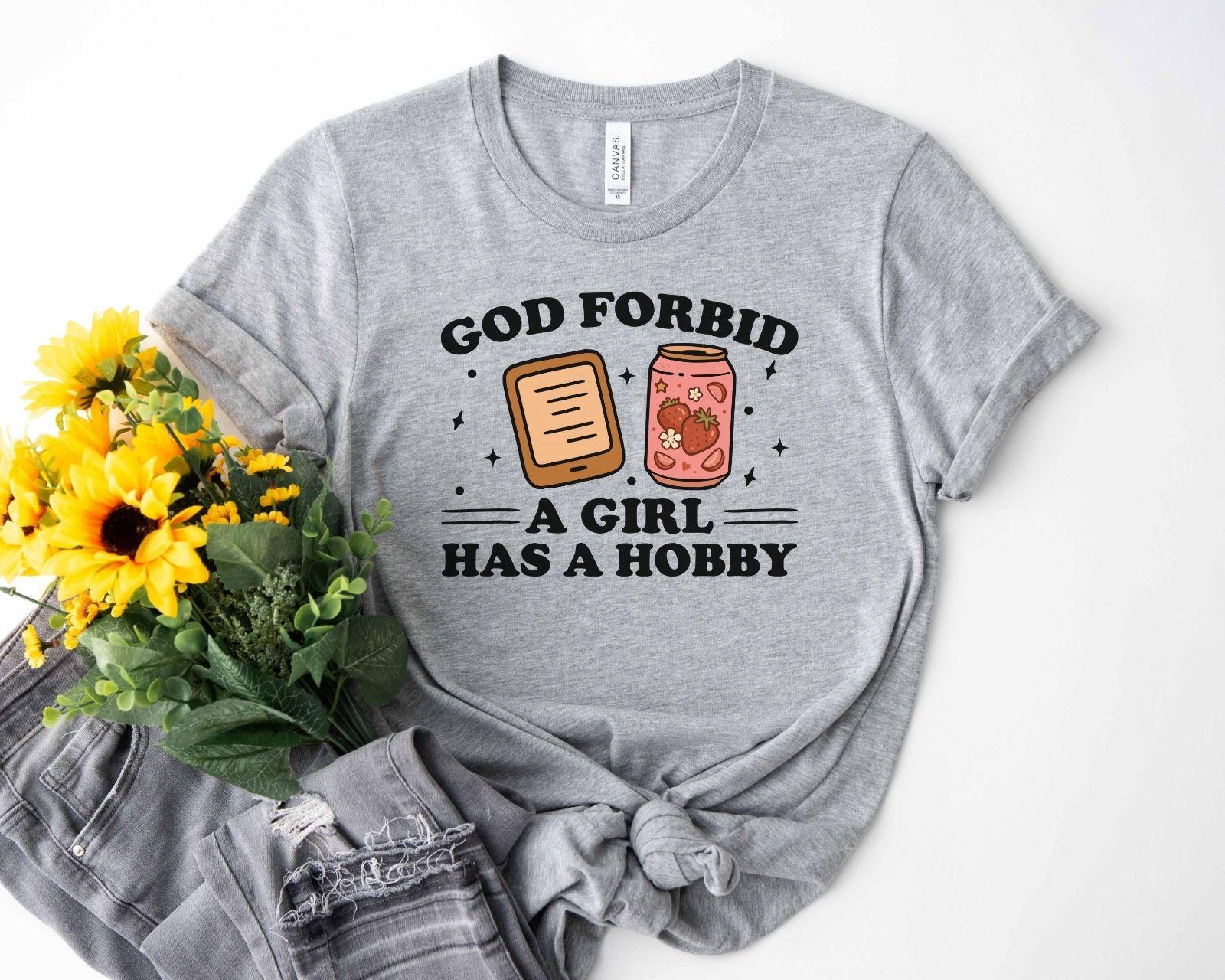 A bella canvas 3001 shirt with the saying "god forbid a girl has a hobby"