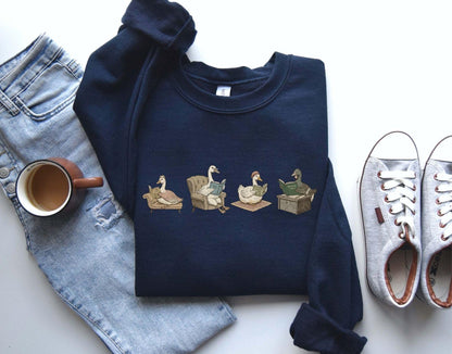A Gildan 18000 sweatshirt with the saying "goose reading a book"