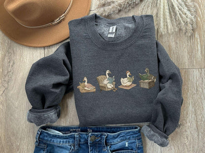 A Gildan 18000 sweatshirt with the saying "goose reading a book"