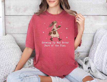 A comfort colors® shirt with the saying "Growing Up Was Never Part of the Plan "