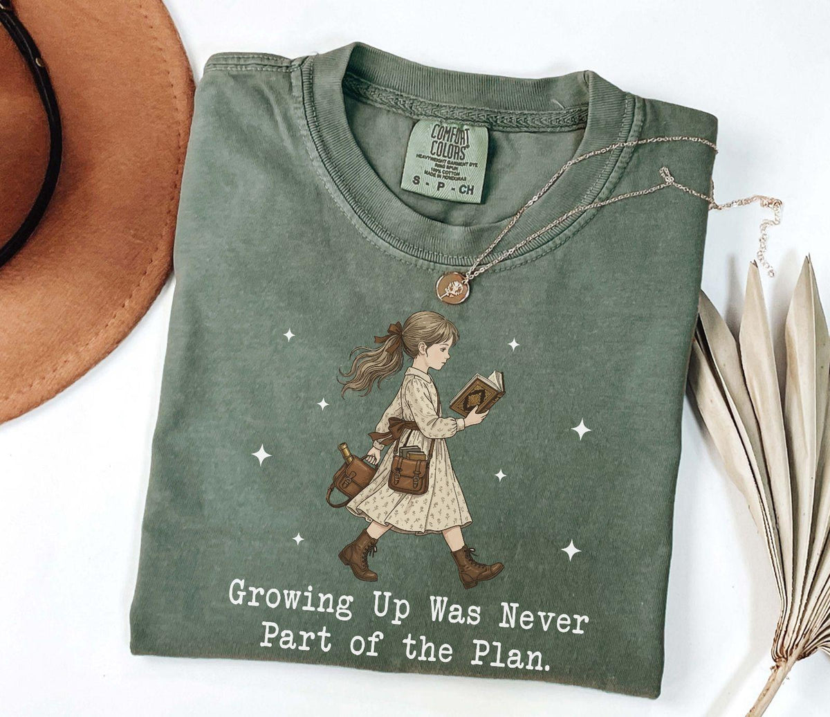 A comfort colors® shirt with the saying "Growing Up Was Never Part of the Plan "