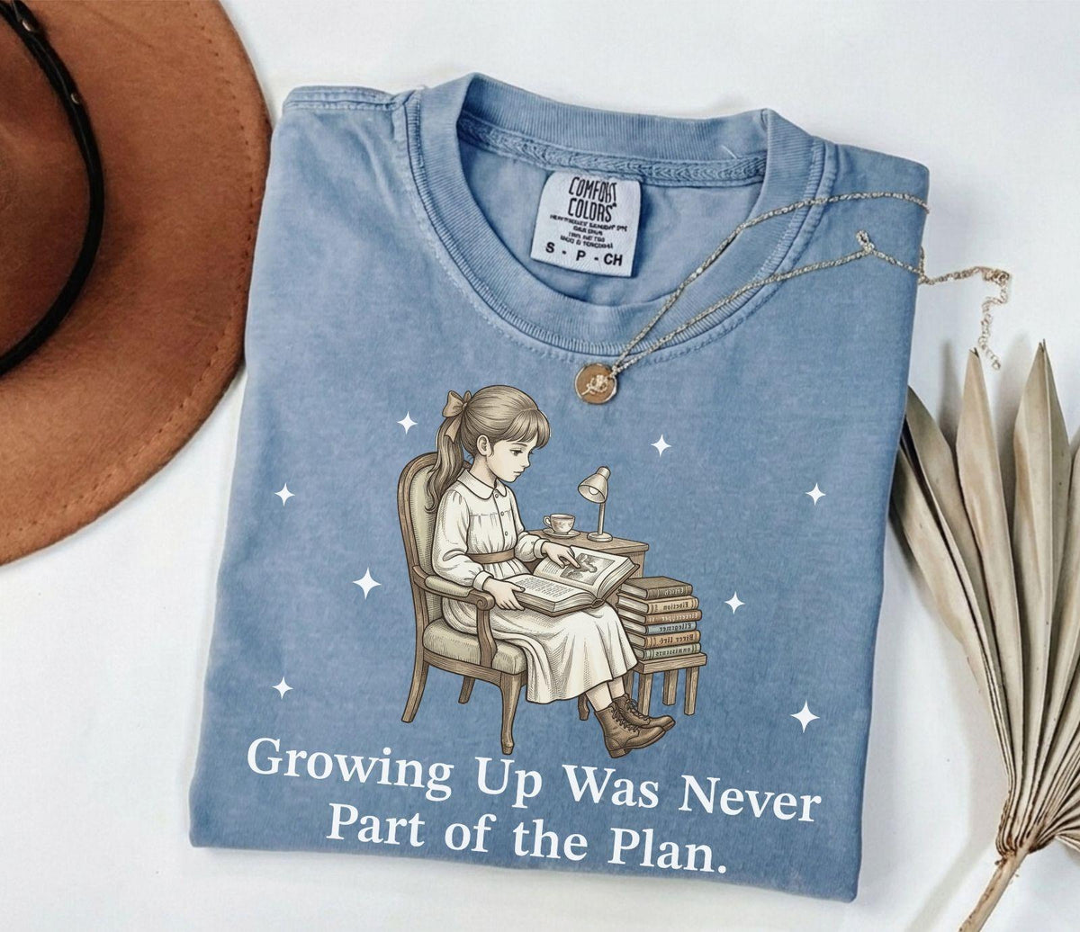 A comfort colors® shirt with the saying "Growing Up Was Never Part of the Plan"