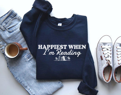 A Gildan 18000 sweatshirt with the saying "Happiest when I'm reading"