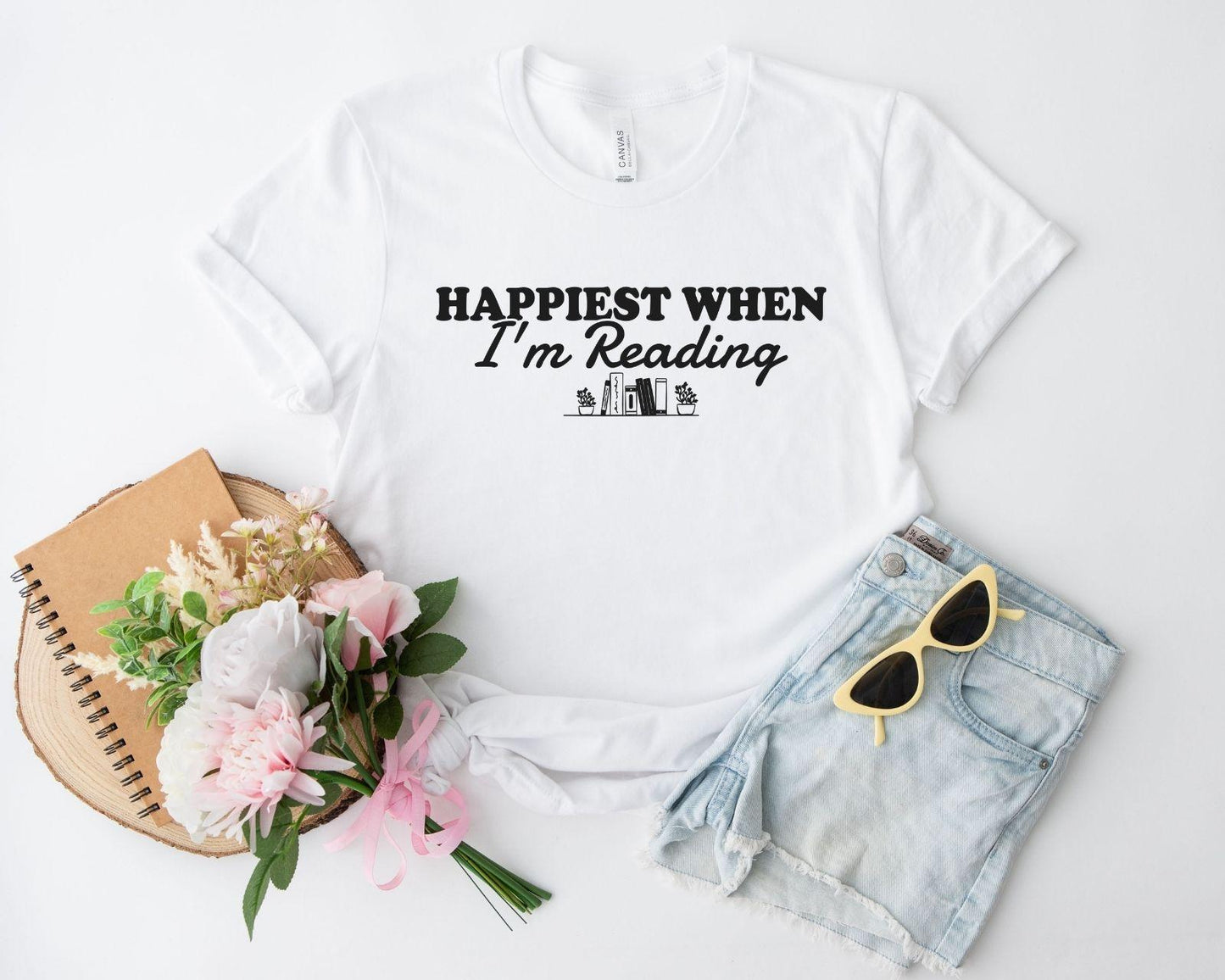 A bella canvas 3001 shirt with the saying "happiest when i'm reading"