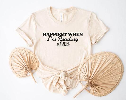 A bella canvas 3001 shirt with the saying "happiest when i'm reading"