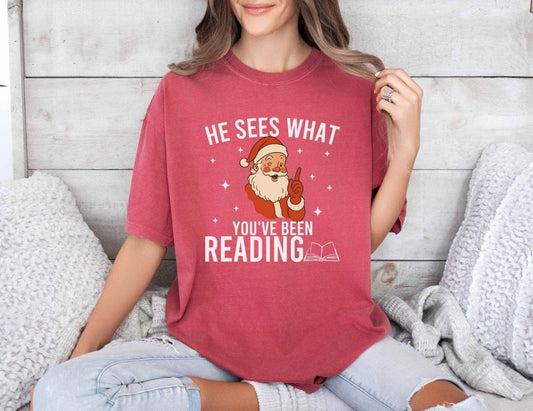 A comfort colors shirt with the saying "He sees what you've been reading"