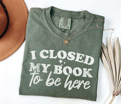A comfort colors shirt with the saying "I closed my book to be here"