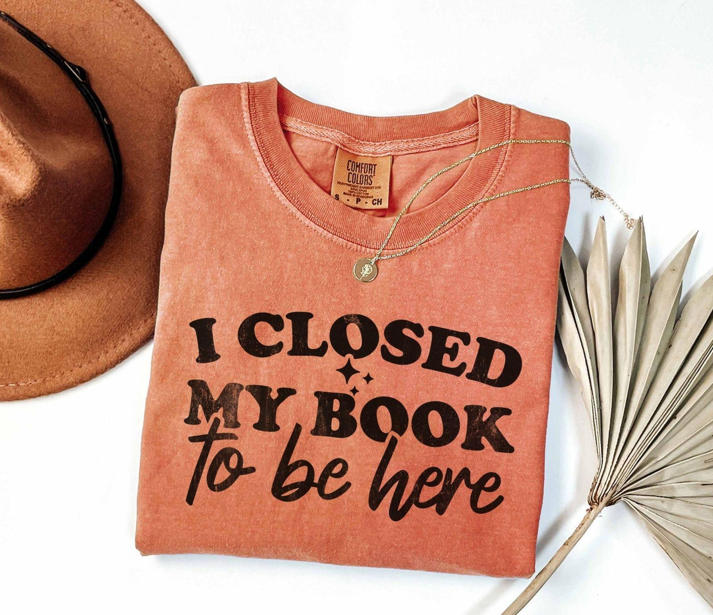 A comfort colors shirt with the saying "I closed my book to be here"