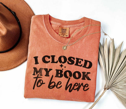 A comfort colors shirt with the saying "I closed my book to be here"