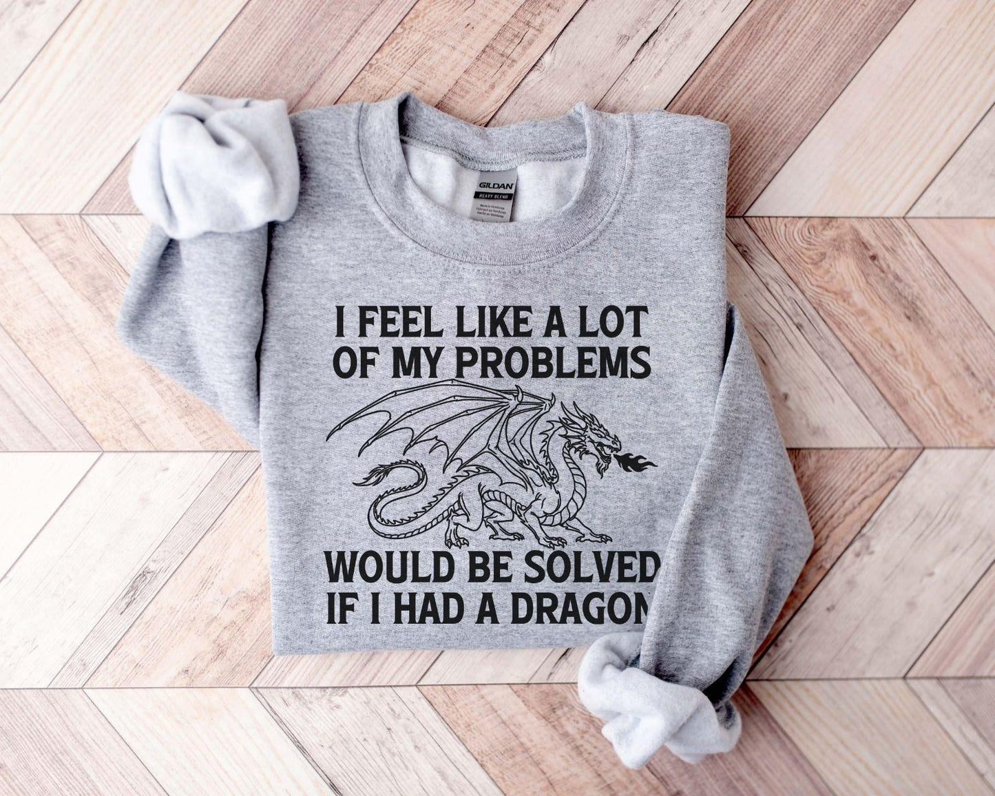 A Gildan 18000 sweatshirt with the saying "I feel like a lot of my problems would be solved if I had a dragon"