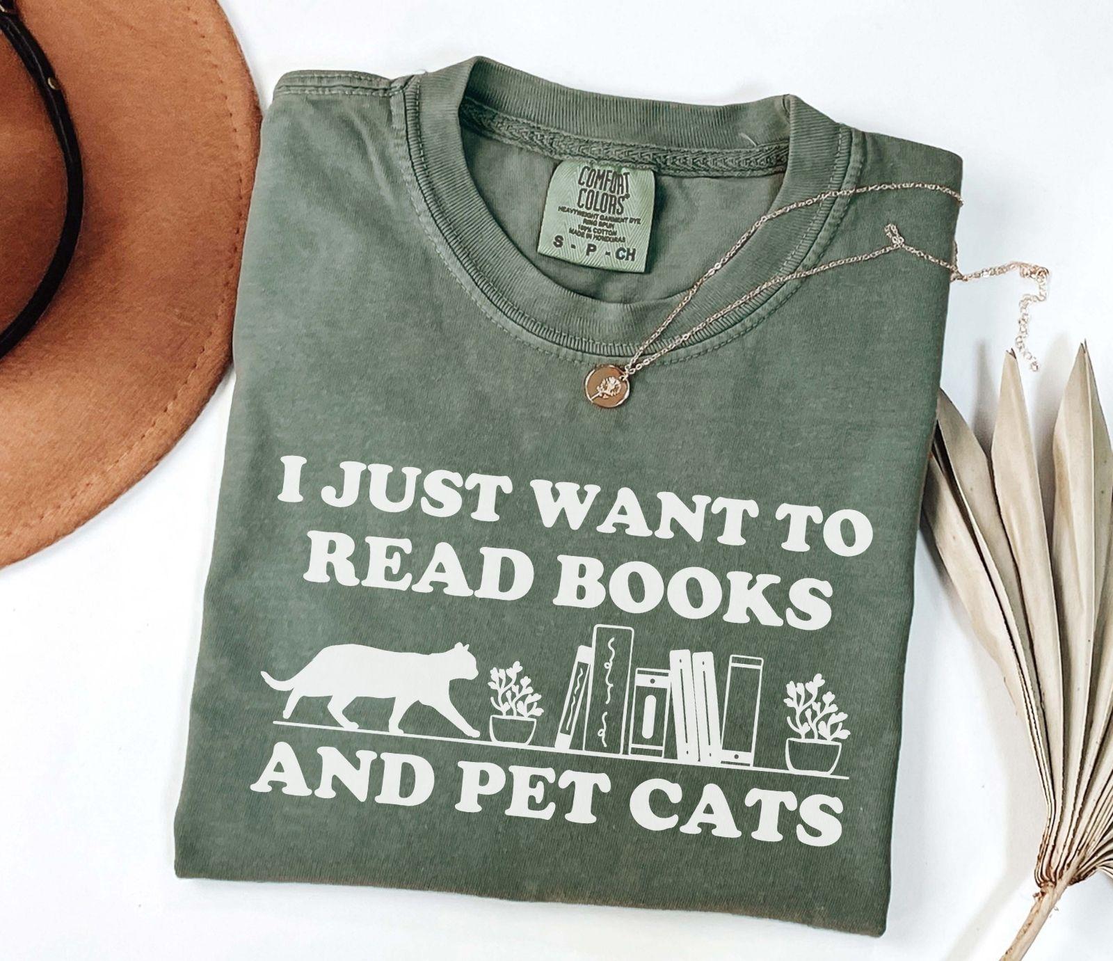 A comfort colors shirt with the saying "I just want to read books and pet cats"