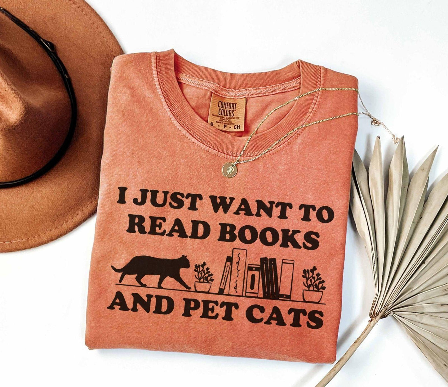 A comfort colors shirt with the saying "I just want to read books and pet cats"