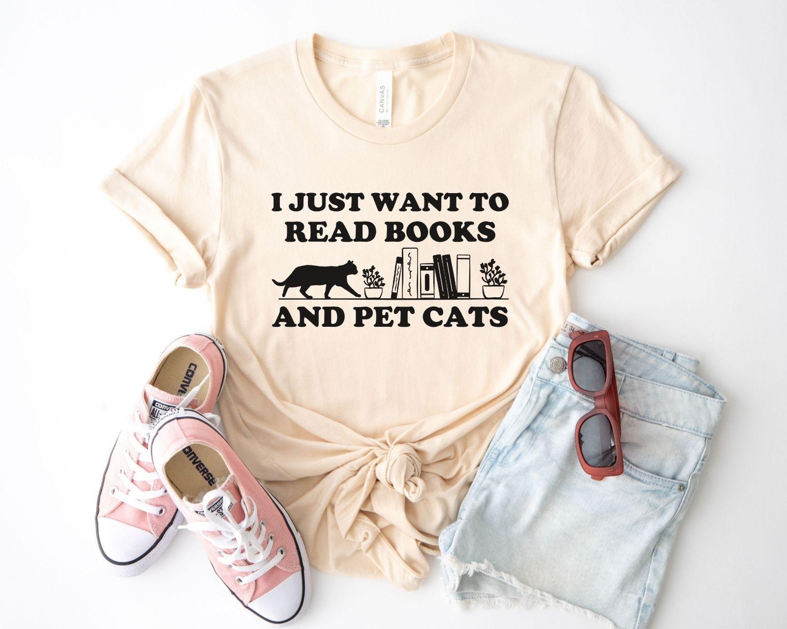 A comfort colors shirt with the saying "I just want to read books and pet cats"