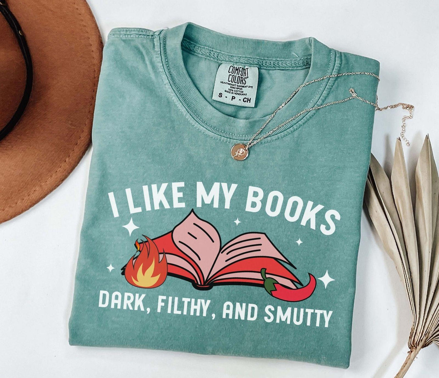 A comfort colors shirt with the saying "I like my books dark filthy and smutty"