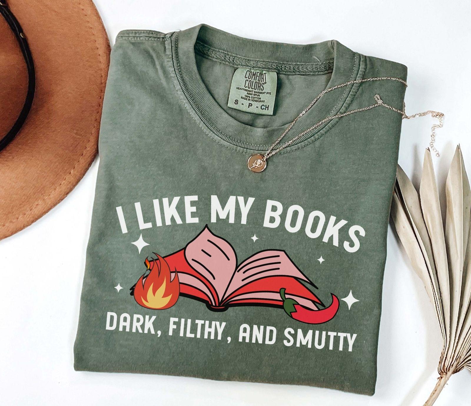 A comfort colors shirt with the saying "I like my books dark filthy and smutty"
