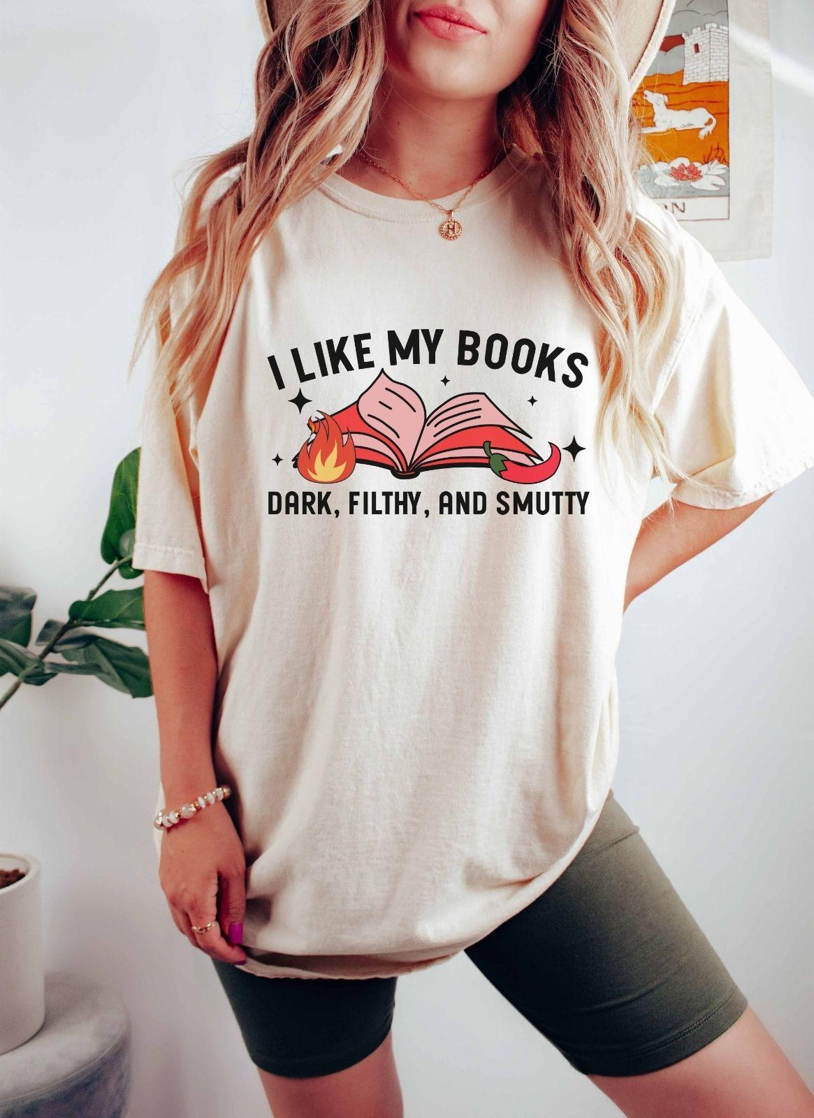 A comfort colors shirt with the saying "I like my books dark filthy and smutty"