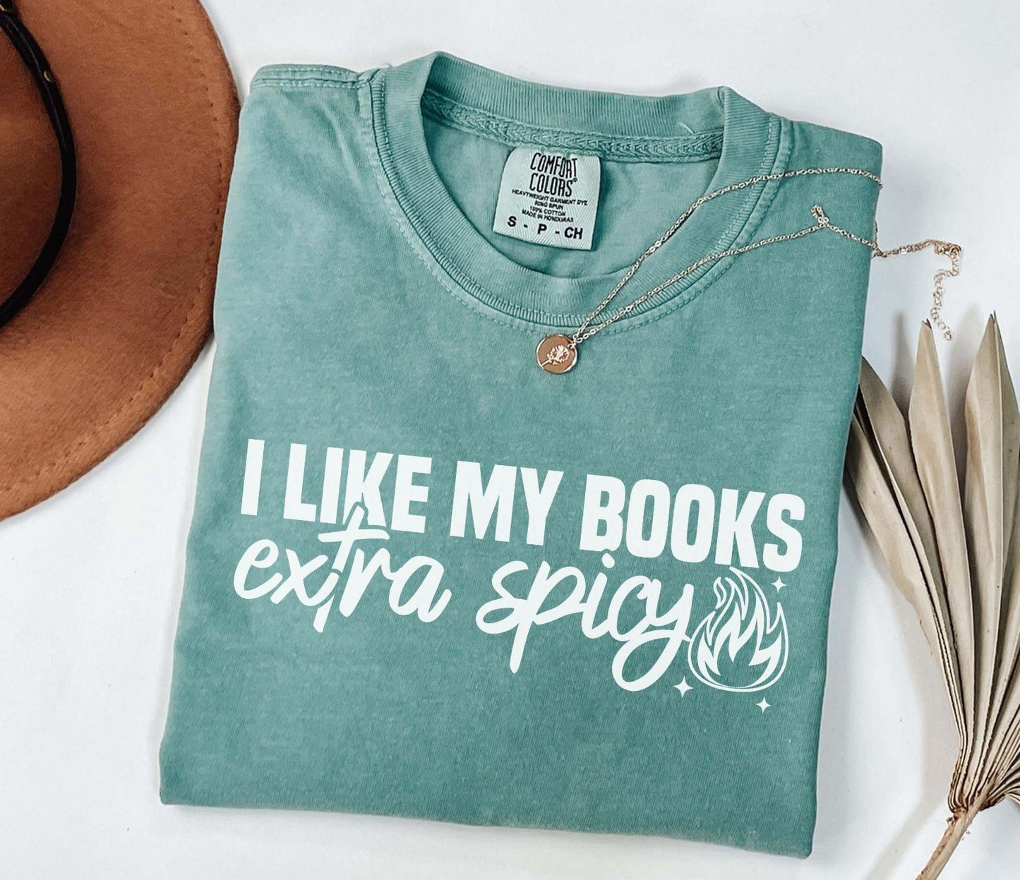A comfort colors shirt with the saying "I like my books extra spicy"