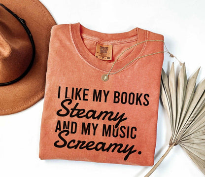 A comfort colors shirt with the saying "I like my books steamy and my music screamy"