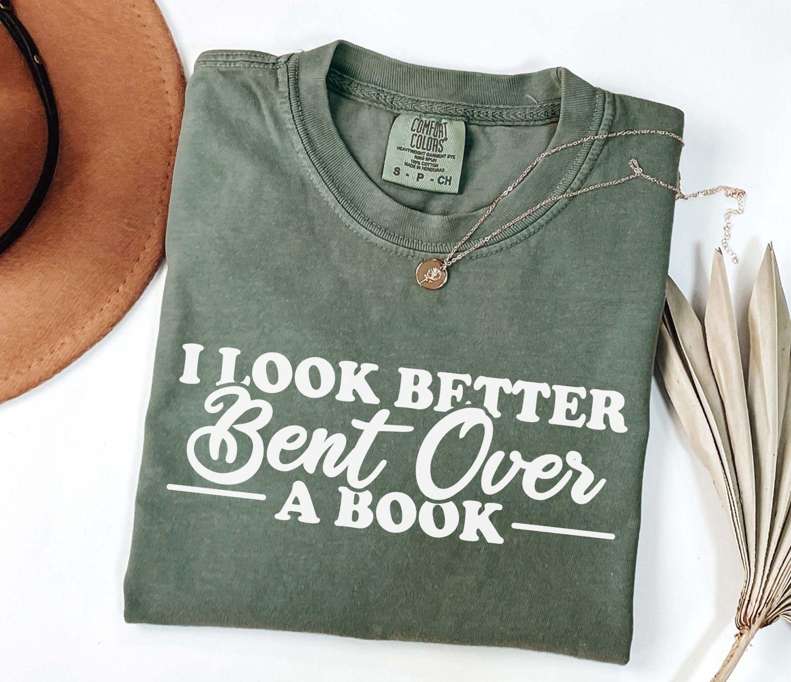 A comfort colors® shirt with the saying "I look better bent over a book"
