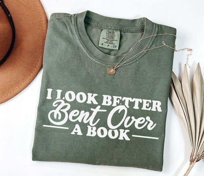 A comfort colors® shirt with the saying "I look better bent over a book"