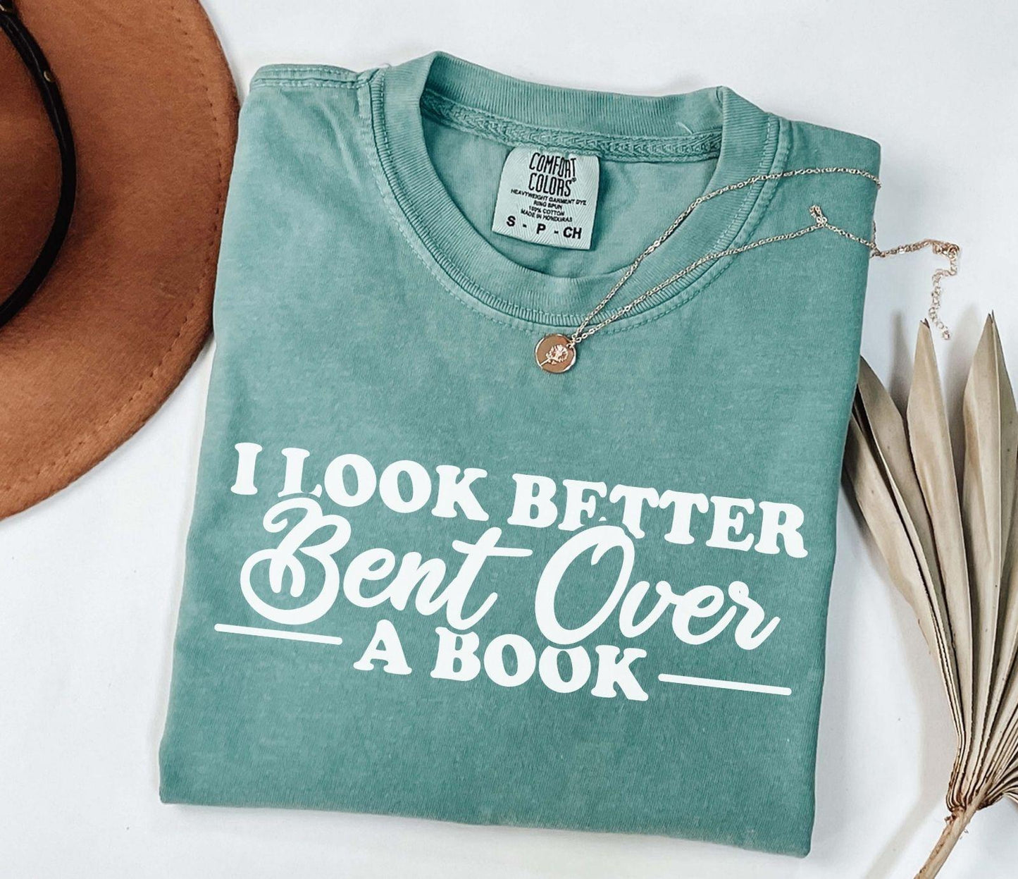 A comfort colors® shirt with the saying "I look better bent over a book"