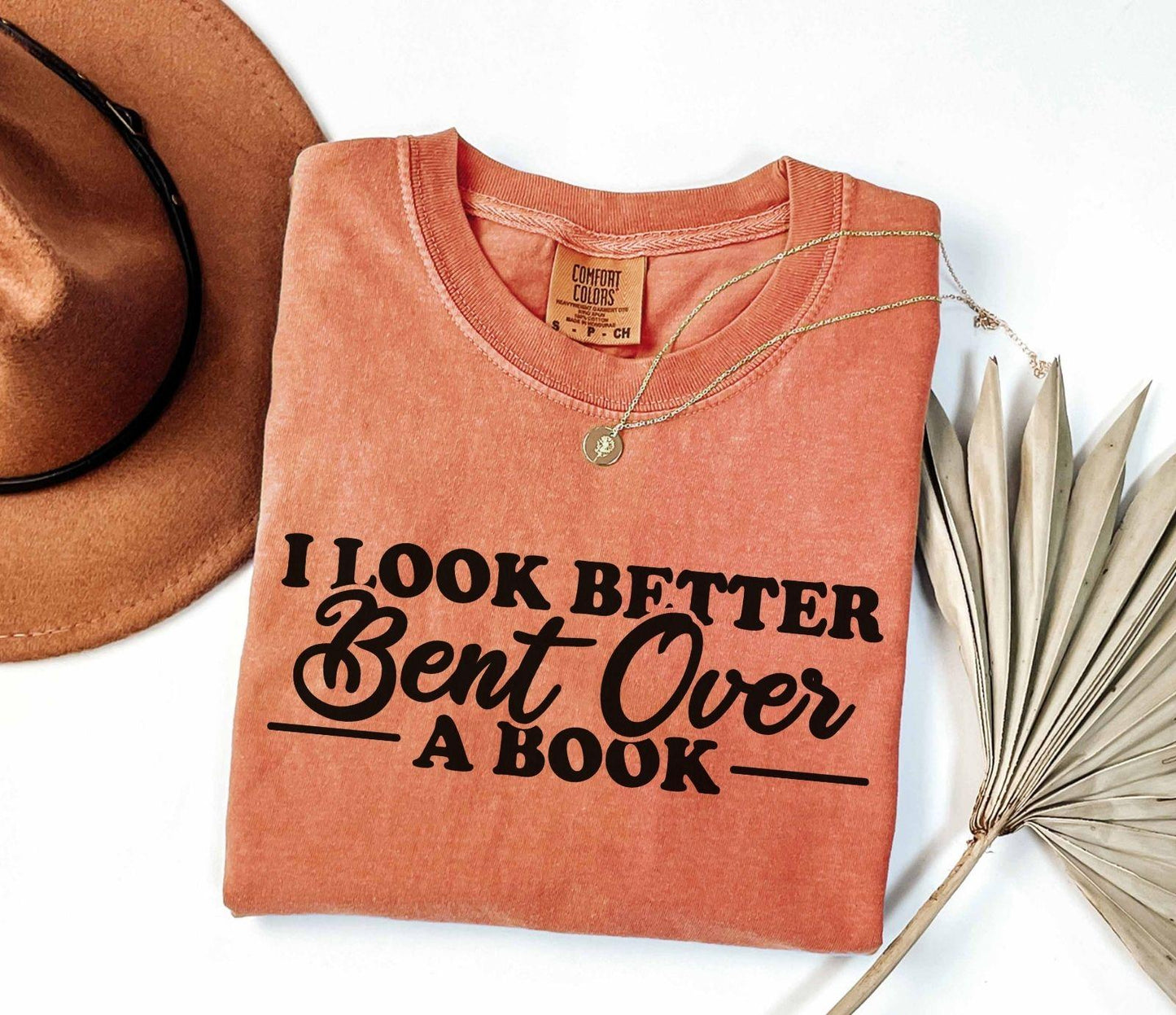 A comfort colors® shirt with the saying "I look better bent over a book"