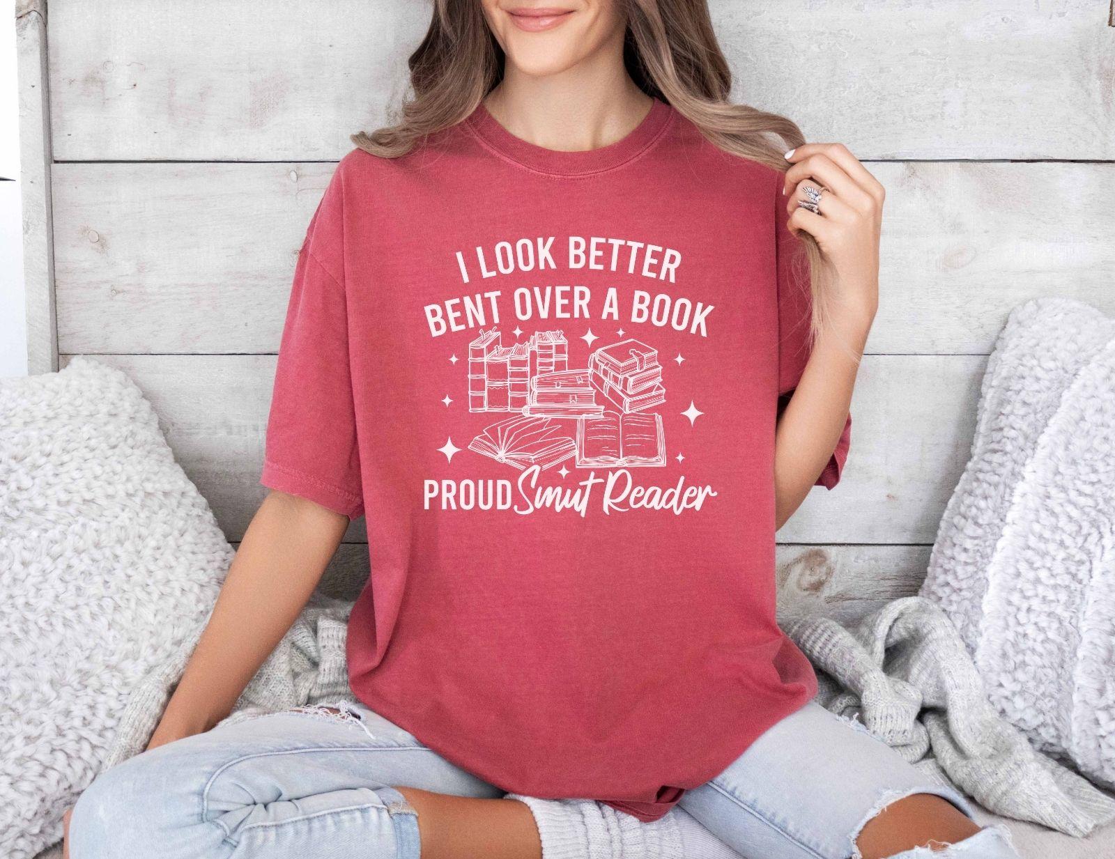 A comfort colors shirt with the saying "I look better bent over a book proud smut reader"