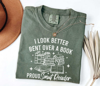 A comfort colors shirt with the saying "I look better bent over a book proud smut reader"