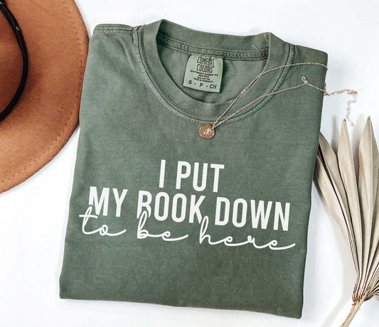 A comfort colors shirt with the saying "I put my book down to be here"