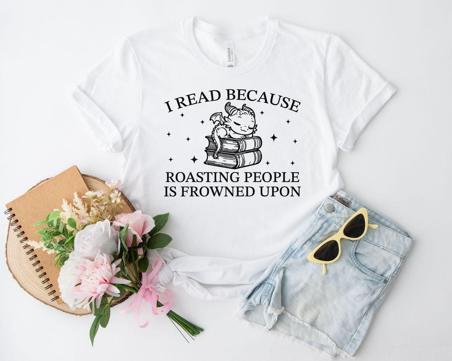 A bella canvas 3001 shirt with the saying "i read because roasting people is frowned upon"