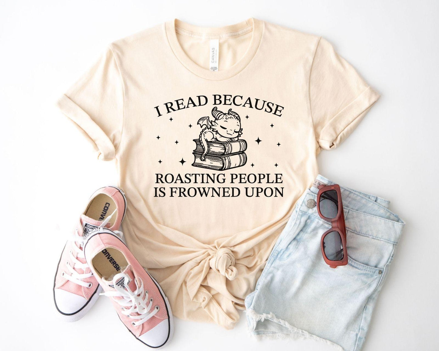 A bella canvas 3001 shirt with the saying "i read because roasting people is frowned upon"