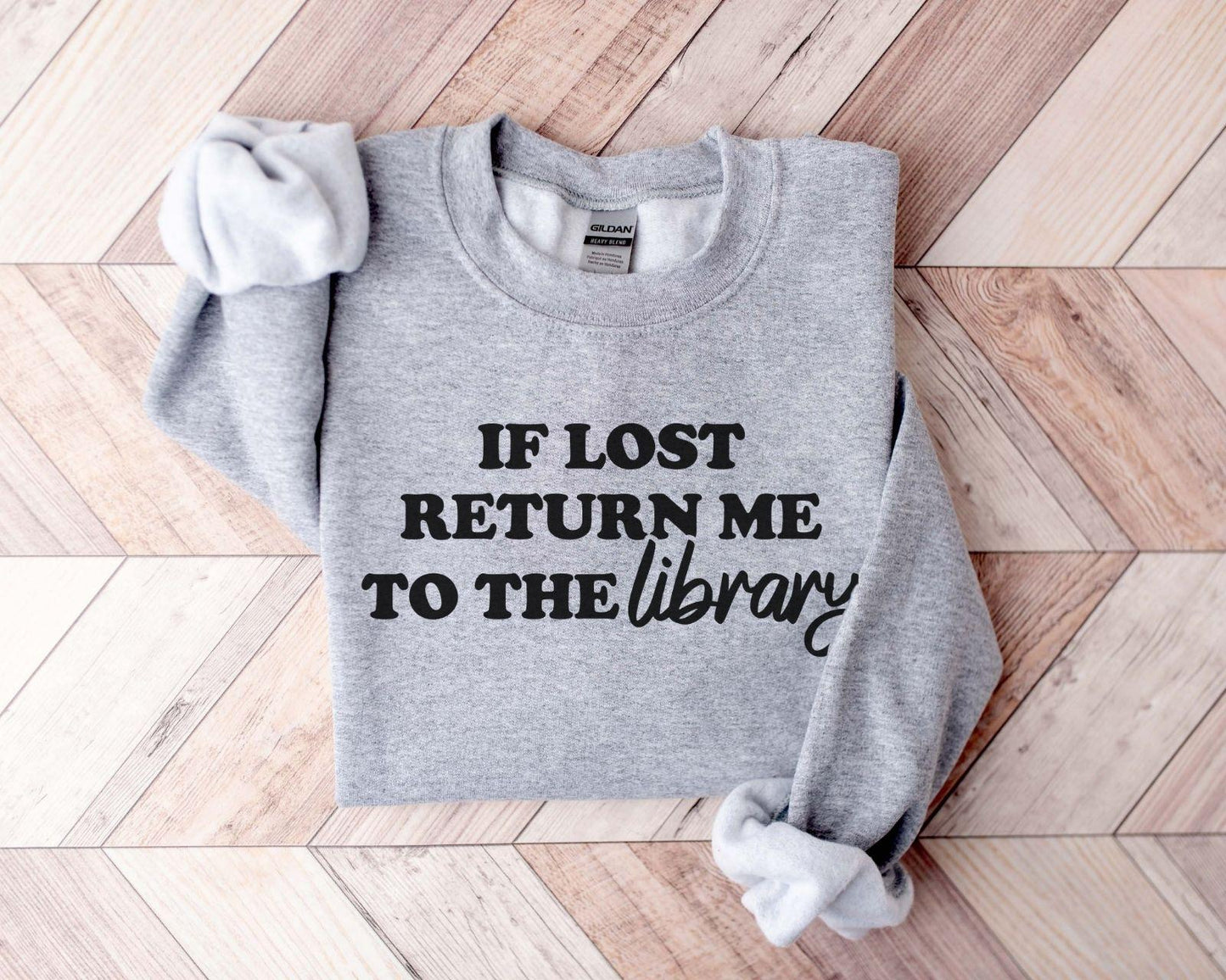 A Gildan 18000 sweatshirt with the saying "if lost return me to the library"