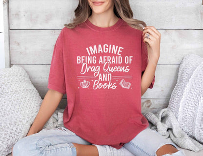 A comfort colors shirt with the saying "Imagine being afraid of drag queens and books"