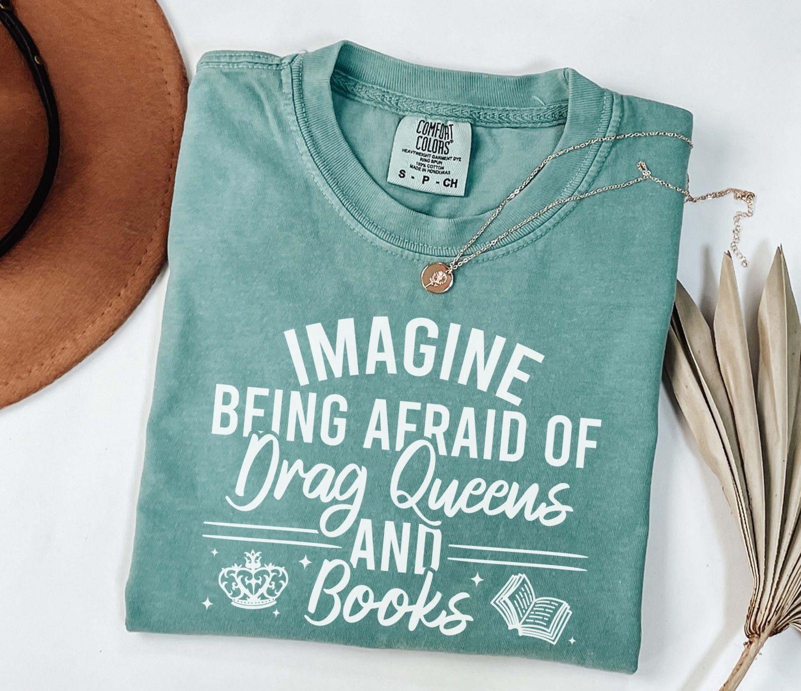 A comfort colors shirt with the saying "Imagine being afraid of drag queens and books"