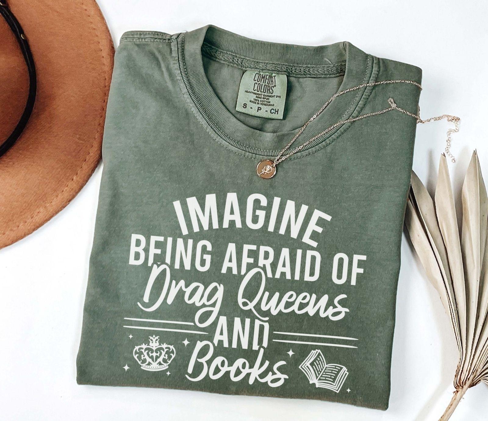 A comfort colors shirt with the saying "Imagine being afraid of drag queens and books"