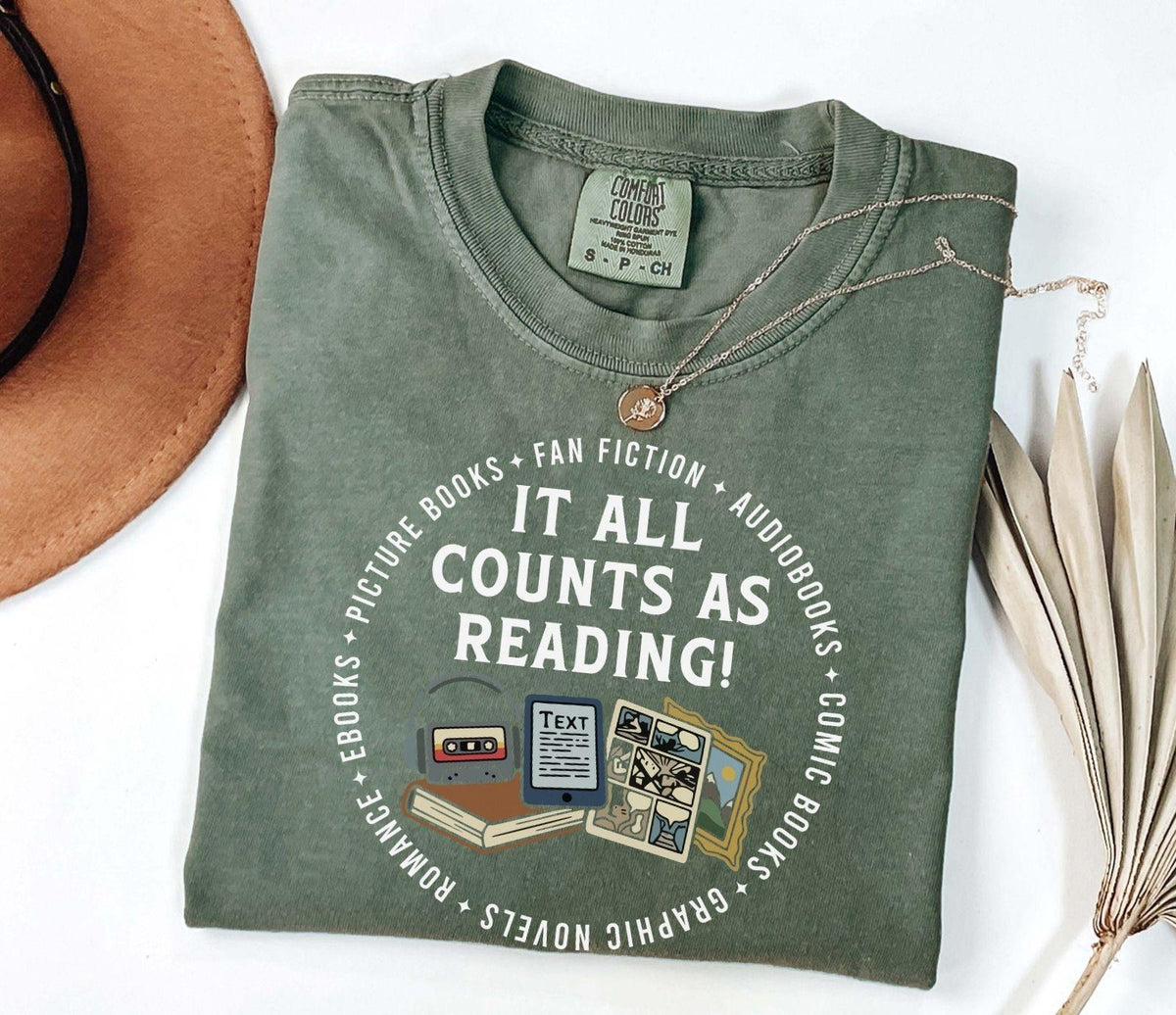 A comfort colors® shirt with the saying "it all counts as reading"
