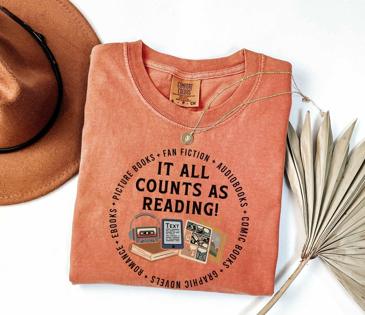 A comfort colors® shirt with the saying "it all counts as reading"