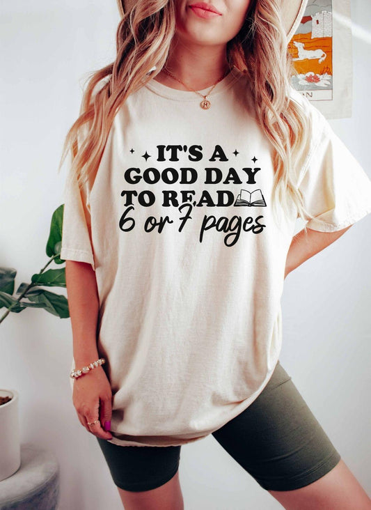 A comfort colors shirt with the saying "It's a good day to read 6 or 7 pages"