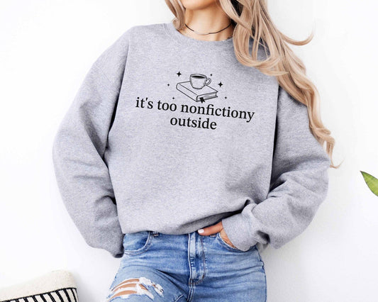 A Gildan 18000 sweatshirt with the saying "it's too nonfictiony outside"