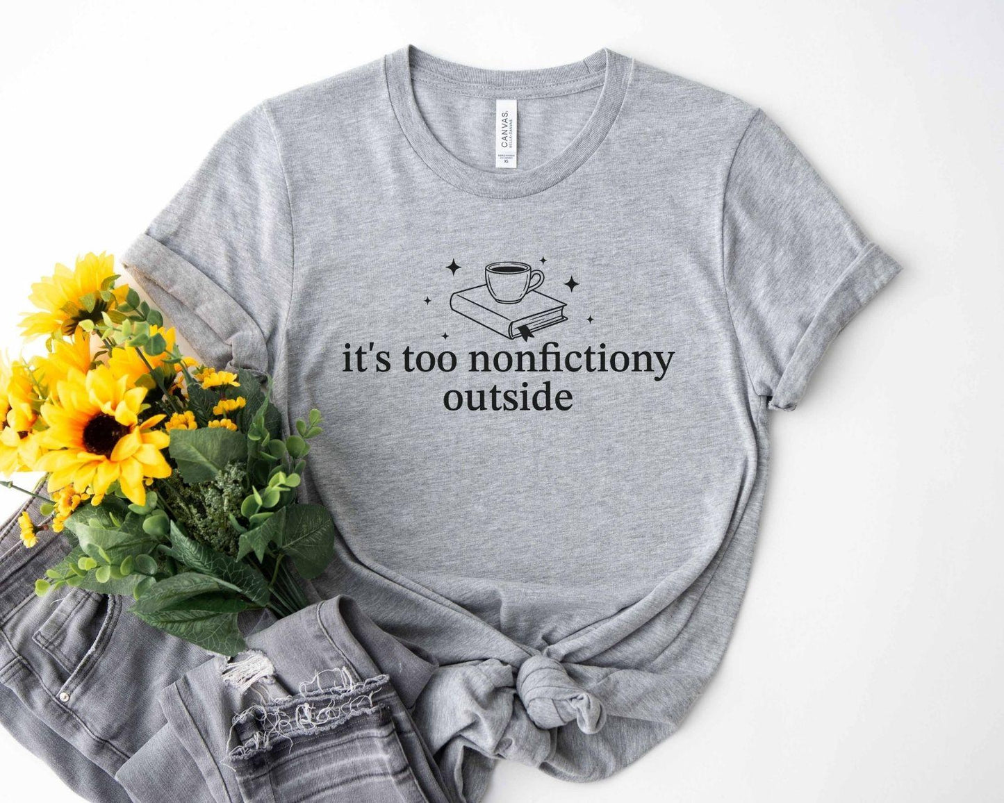 A bella canvas 3001 shirt with the saying "it's too nonfictiony outside"