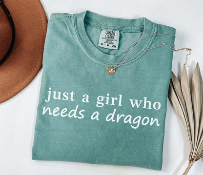 A comfort colors® shirt with the saying "just a girl who needs a dragon"