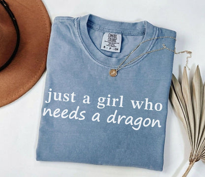 A comfort colors® shirt with the saying "just a girl who needs a dragon"
