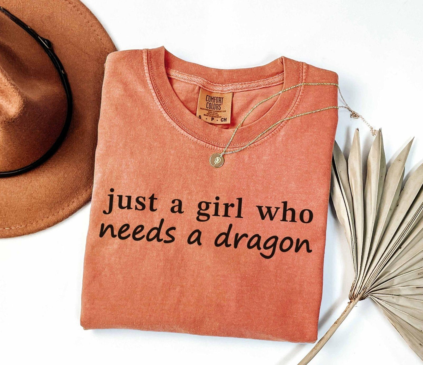 A comfort colors® shirt with the saying "just a girl who needs a dragon"