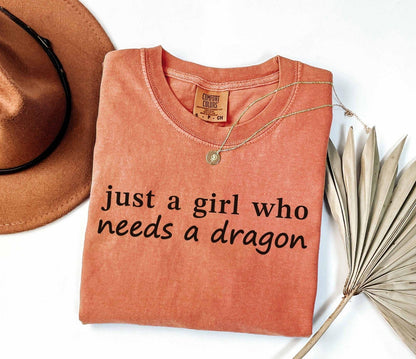 A comfort colors® shirt with the saying "just a girl who needs a dragon"